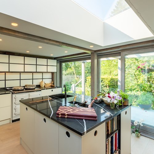 An eastern inspired handle free kitchen with large windows.