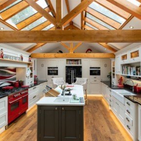 A country style black and white kitchen with classical features, exposed beams and skylights