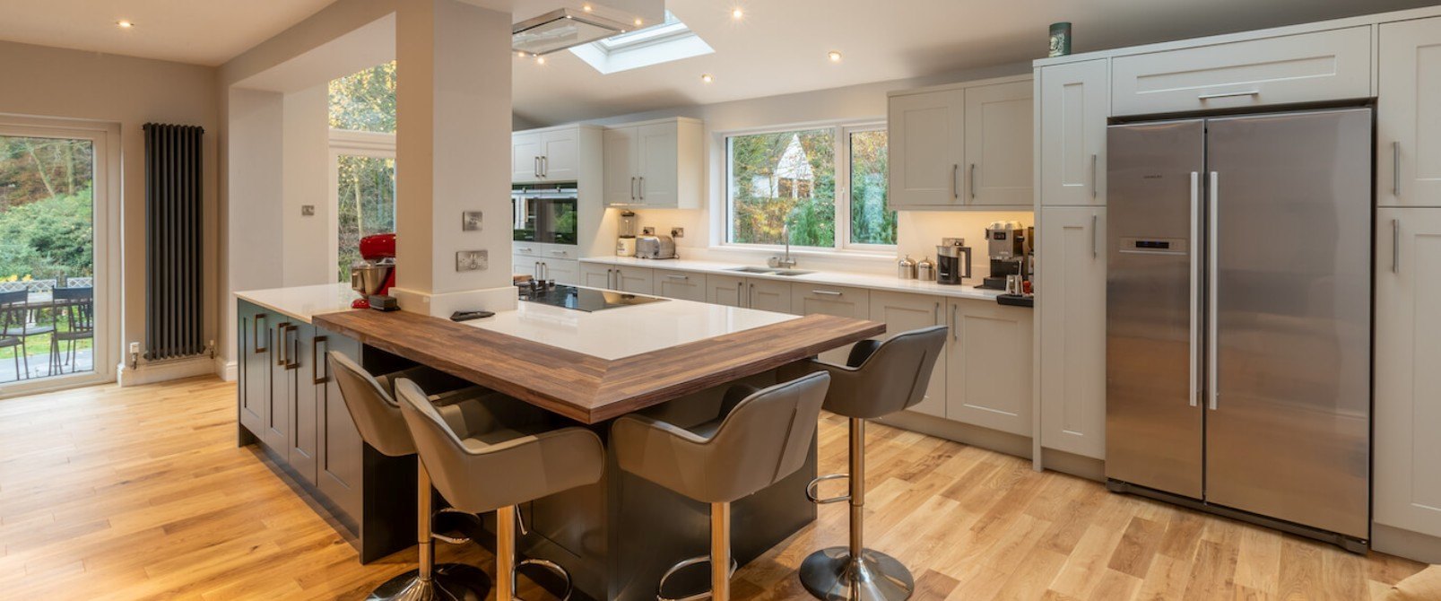 White and blue kitchen with island and oak breakfast bar