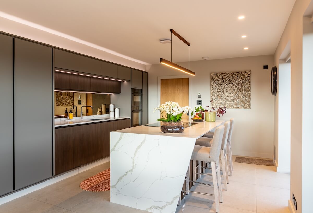Mixed material kitchen with waterfall edge white island
