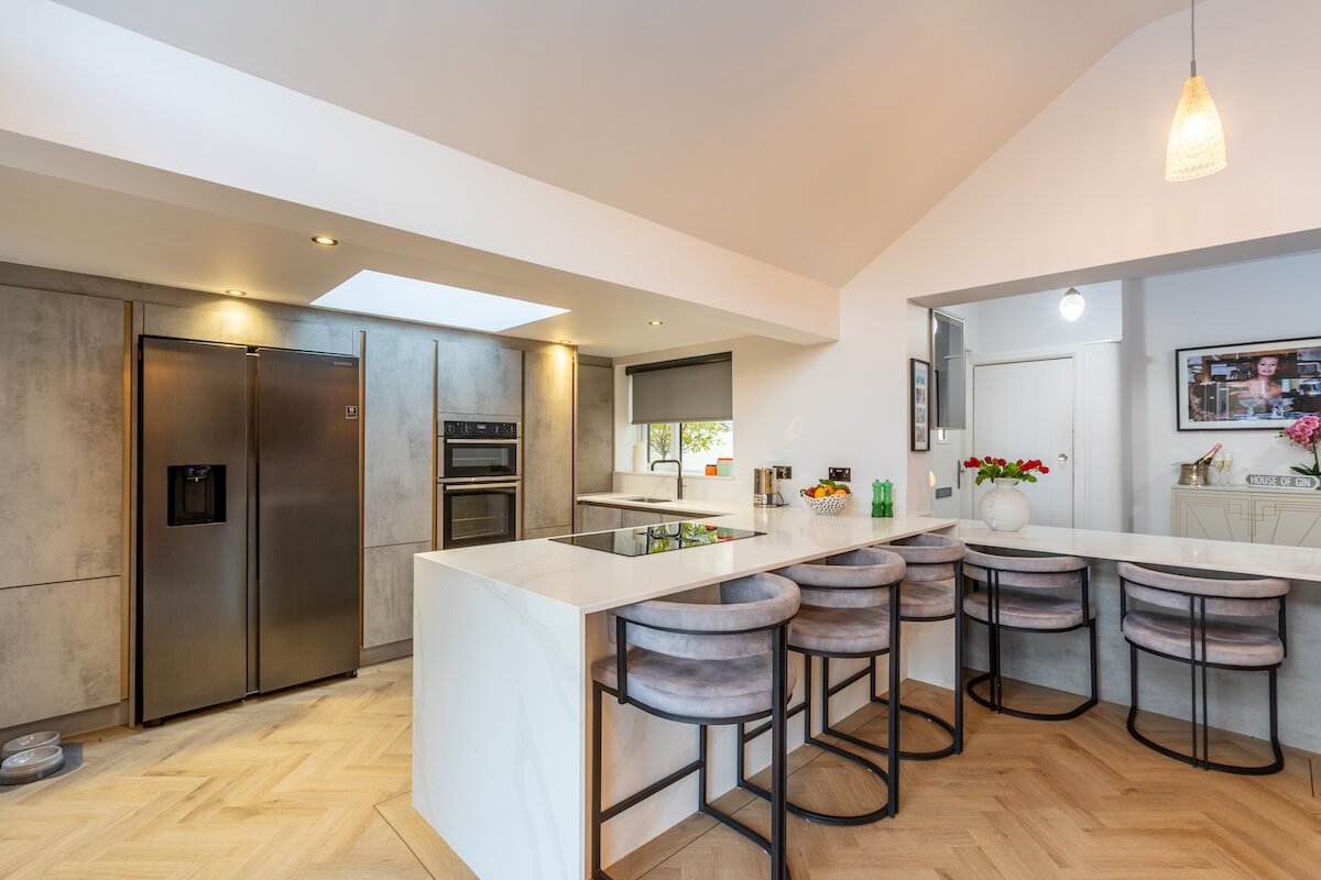 Bespoke kitchen featuring dual island in grey with white worktops and double fridge